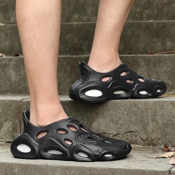 A man in black sneakers stands confidently on steps, showcasing Men's Fashion Outdoor Removable Sole Slippers.