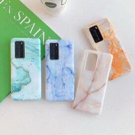 Assortment of Marbled Huawei Phone Cases in blue, orange, and pink hues displayed beside a ‘Spain’ travel book.