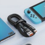 6A Fast Charging Mobile Phone Data Cable neatly coiled next to a blue smartphone and gaming console on a light surface, highlighting the cable’s compatibility and quick charging feature.