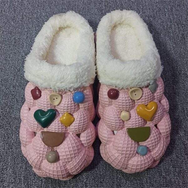 A pair of pink cotton slippers adorned with heart patterns, designed for warmth and non-slip comfort.