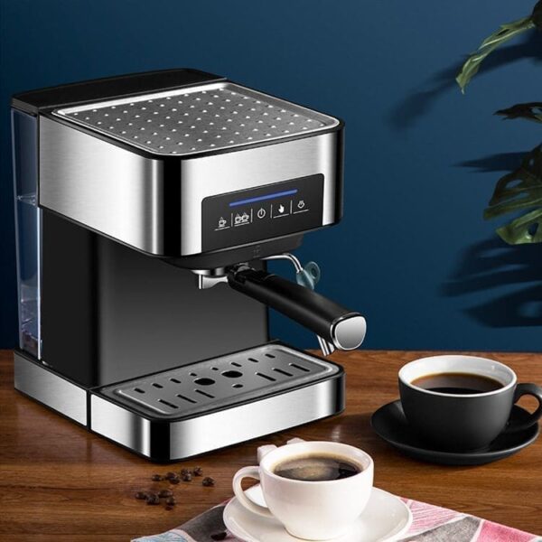 A black and silver espresso machine with a cup of coffee and coffee beans on a wooden table