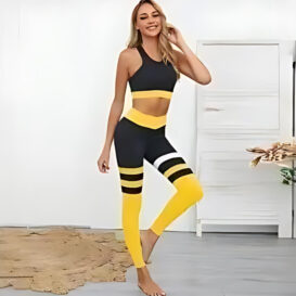 A woman wearing a stylish and sporty Quick-drying yoga apparel. Apparel has a black sports bra with a racerback style and high-waisted black leggings.