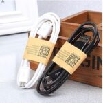 Android Universal Data Cable with white and black variants wrapped neatly, secured with golden clasps, displayed against a wooden box background.