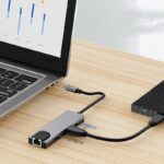 5-in-1 Type-C to HDMI USB Expansion Dock connected to a laptop and external monitor, showcasing its multi-port functionality.