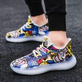 trendy men’s sports shoes with colorful comic print design on a pavement background, showcasing a modern and stylish footwear choice for active lifestyles.