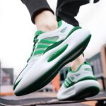 Close-up of breathable mesh running sneakers for men in action, showcasing the lightweight design and vibrant green and white color scheme on a dynamic background