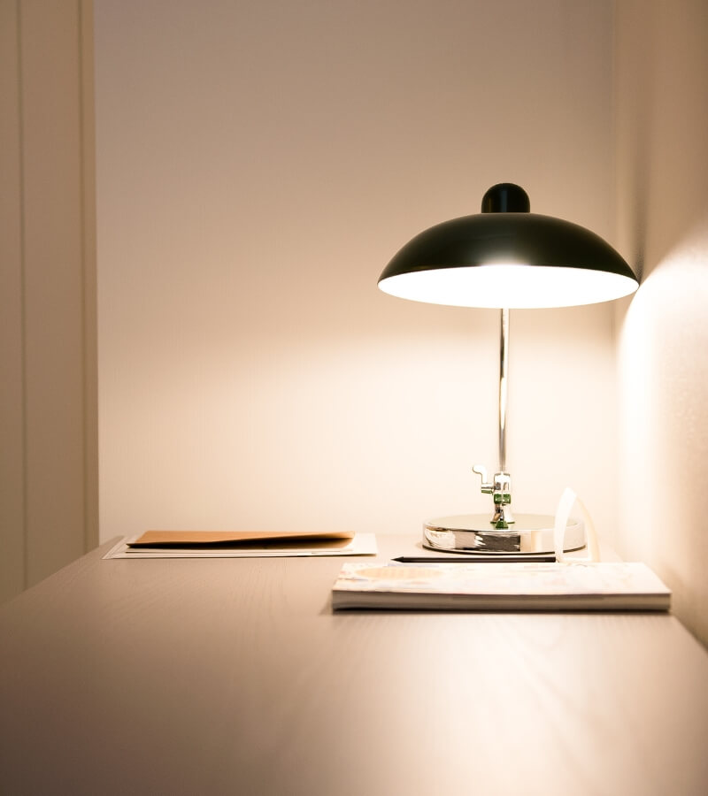 a well-lit study space with a sleek desk lamp casting a warm glow over an organized workspace